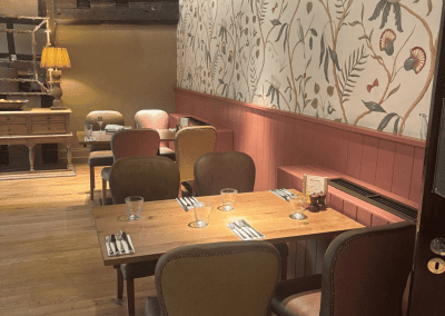 Bespoke pub furniture and soft furnishings featuring comfortable seating, dining tables, and curtains designed to complement the venue’s warm, rustic interior.