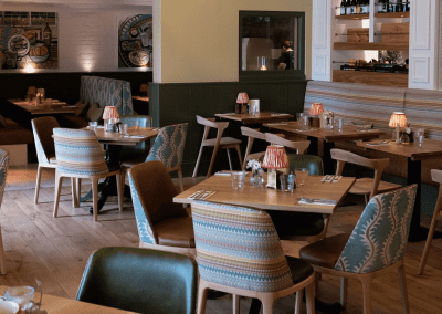 Bespoke pub furniture and soft furnishings at The Long Hop Pub, featuring comfortable seating, dining tables, and curtains designed to complement the venue’s warm, rustic interior.