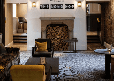 Bespoke pub furniture and soft furnishings featuring comfortable seating, dining tables, and curtains designed to complement the venue’s warm, rustic interior.