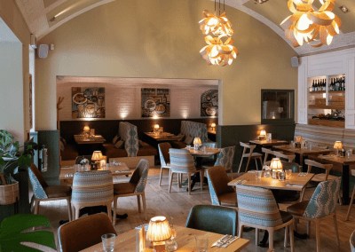 Bespoke pub furniture and soft furnishings featuring comfortable seating, dining tables, and curtains designed to complement the venue’s warm, rustic interior.