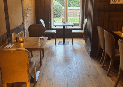 Bespoke pub furniture and soft furnishings featuring comfortable seating, dining tables, and curtains designed to complement the venue’s warm, rustic interior.